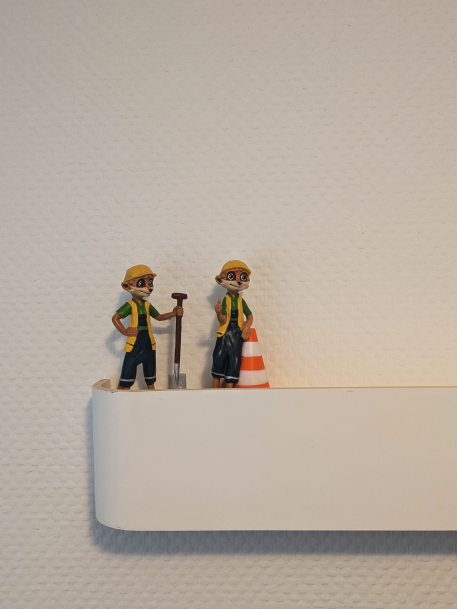 Was macht eine Erziehungsstelle aus? Zwei Figuren von Frettchen in Bauarbeiter*innen Klamotten.