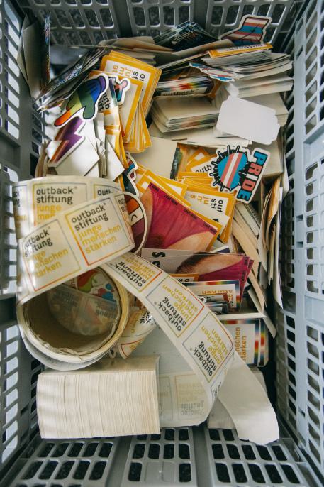 Pflegefamilie Fachpflegestelle Eine Kiste voller Sticker und kleinen Goodies mit dem outback Logo
