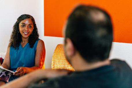 Kinder und Jugendhilfe kurz erklärt Eine Frau ist zu sehen wie sie einer anderen Person die uns den Rücken gekehrt hat etwas erklärt.