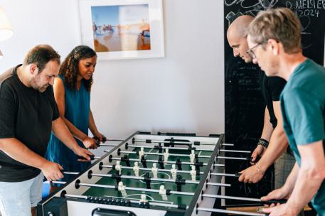 Familienhilfe vier Menschen spielen zusammen Kicker