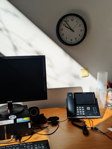 Selbstständigkeit Ein Arbeitsplatz mit PC Bildschirm, einem Telefon und einer Uhr an der Wand Selbstständigkeit Ein Arbeitsplatz mit PC Bildschirm, einem Telefon und einer Uhr an der Wand